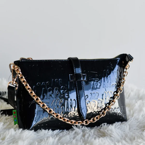 Diseño elegante y multifuncional en una sola pieza. Esta bandolera plana, que también puede usarse como cartera de mano, está confeccionada en charol estructurado con el logo ARP grabado, aportando textura y personalidad a cualquier look.Su formato con cremallera superior es perfecto para llevar lo esencial con estilo. Además, incluye cadena corta para un uso más formal y correa larga ajustable para llevar cruzada o al hombro. Ideal como bolso de noche o para el día a día si buscas un accesorio sofisticado y práctico. Medidas: 26*16*3