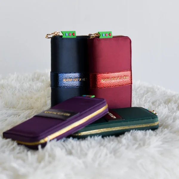 Elegancia y practicidad en un diseño compacto. Este billetero de la colección Nube destaca por la línea central en piel sintética metalizada, sobre la que se sitúa el logo dorado de Agatha Ruiz de la Prada, aportando un toque sofisticado y moderno. Cuenta con una cremallera única que abre el acceso al interior, donde encontrarás un bolsillo adicional con cremallera para organizar mejor tus monedas y tarjetas. El tirador con el icónico icono de la nube remata un diseño exclusivo y funcional. Medidas: 19*9*2