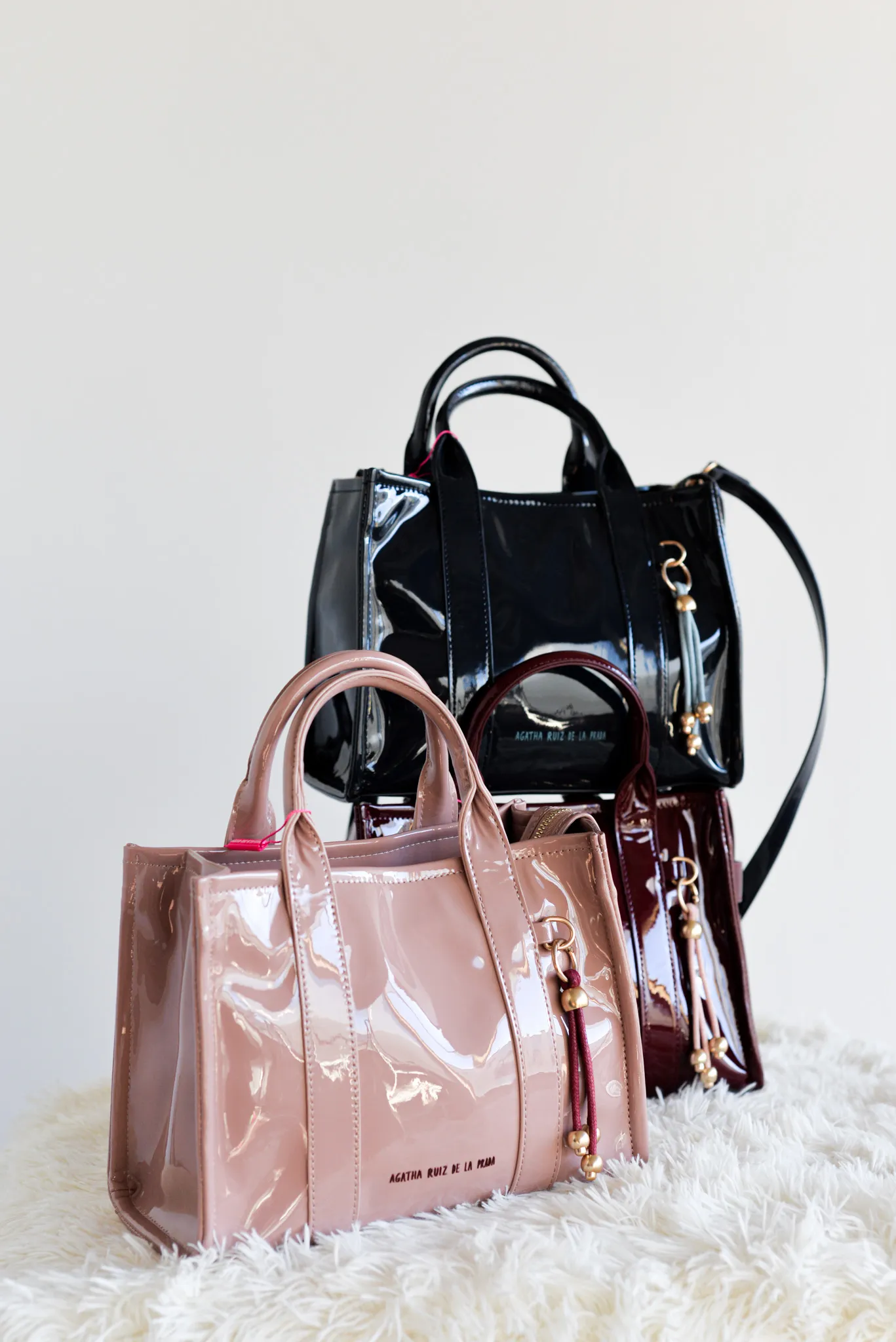 Bolso en formato bowling diseñado en piel sintetica con detalles en charol en el mismo tono. Cremallera superior. Iniciales Agatha Ruiz de la Prada en el frente en letras de metal. Bolsillo de seguridad trasero con cremallera. Incluye correa para poder usar como bolso bandolera tambien. Medidas: 25 cm.