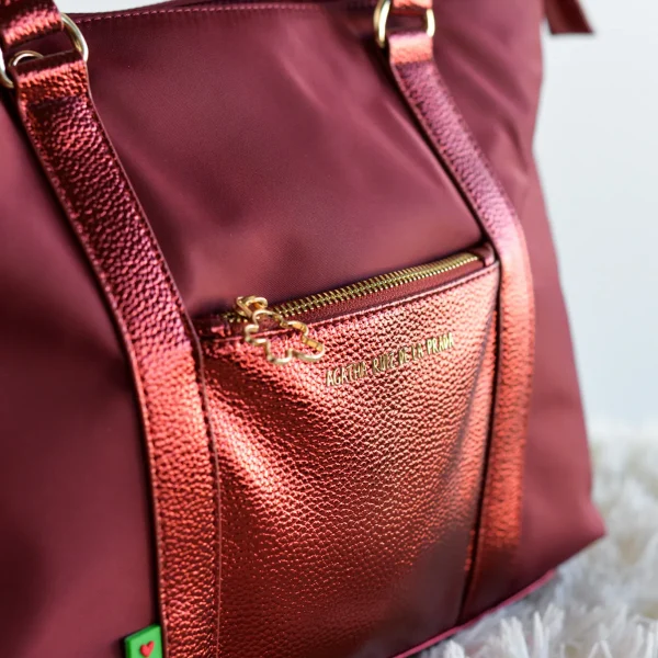 Ligero, funcional y con un toque de sofisticación. Este bolso shopper extra grande combina la resistencia y frescura del nylon con la elegancia de la piel sintética metalizada a tono, creando un accesorio versátil para el día a día. Gracias a su peso pluma y cierre superior con cremallera, es ideal para llevar todo lo que necesitas con total comodidad y seguridad. Los detalles en dorado y el icono de la nube en el tirador aportan ese sello único y exclusivo que define la colección Agatha Ruiz de la Prada. Medidas: 35*26*10