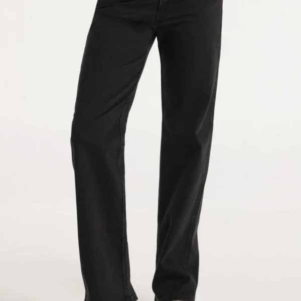 Jeans de tiro medio que se asienta justo por debajo de la cintura. Confeccionados en un 98% de algodón y un 2% de elastano, ofrecen una ligera elasticidad que permite libertad de movimiento sin perder su forma. El acabado washed black les da un aspecto desgastado y versátil, ideal para combinar con diversas prendas y estilos. Su color negro los convierte en una pieza esencial y atemporal en cualquier guardarropa femenino.