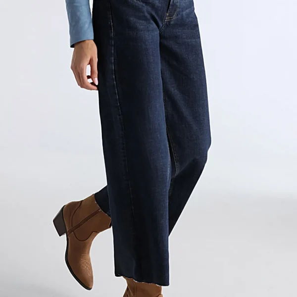 Es un modelo de jeans para mujer que presenta un diseño recto y ancho con un corte cropped, lo que significa que el largo del pantalón llega hasta un poco más arriba del tobillo. Estos jeans tienen un tiro medio, proporcionando un ajuste cómodo y moderno. El estilo Cross Rinse Wash se refiere a un lavado especial que le da al tejido un acabado único y distintivo en color azul. Están confeccionados con una mezcla de 98% algodón y 2% elastano, lo que ofrece una combinación de suavidad, durabilidad y elasticidad para un ajuste favorecedor y cómodo.