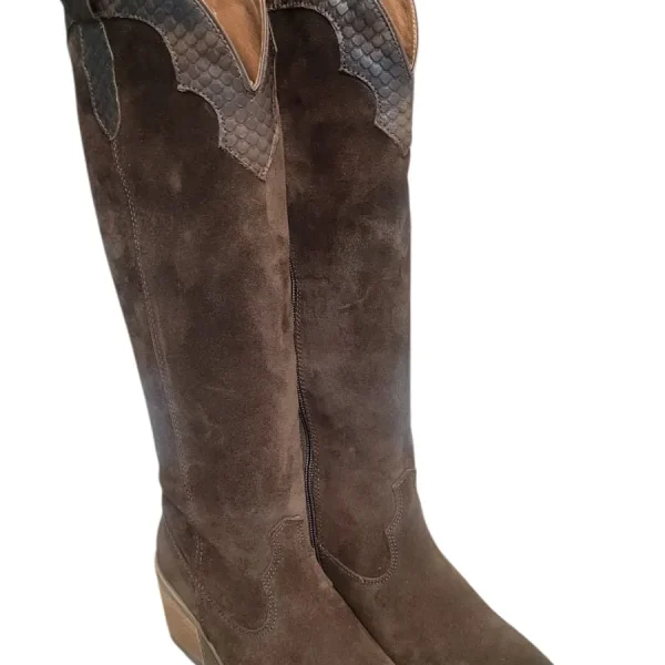 Bota campera wester combinada en suave ante marrón con piel de serpiente al tono. Cierre con cremallera lateral para facilitar el calce. Una bota fabricada en España por expertos maestro en la manufacturación de cuero natural. Abalorio metalico en el tacón , en acabado de bronce envejecido. Forro interior de piel y plantilla acolchada no extraible. Suela de goma. Altura de tacón 6,5 cm y altura de caña 46 cm. 