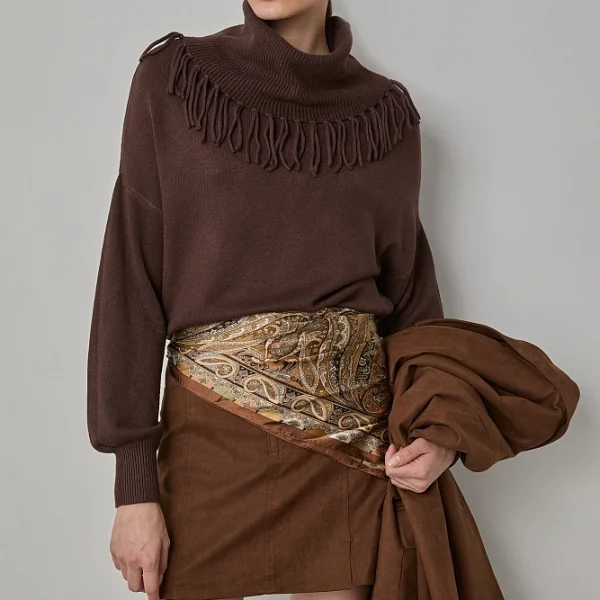 Suéter de manga larga, con cuello alto, con flecos, corte regular, textura suave.