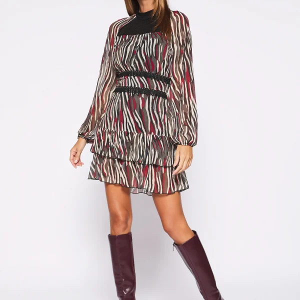 Vestido de gasa estampada, combinando crochet y tachas doradas. Falda de volantes y cintura elástica. Va forrado. Composición: 100% poliéster