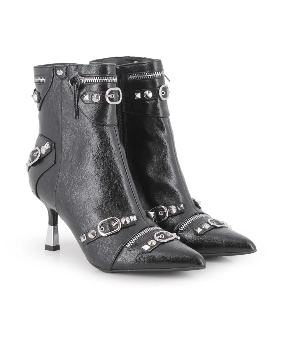 BOTINES BERNABELLA.1 Botines negros con punta afilada y tacón fino de 5 cm. Caña de 15 cm decorada con cierres, tachuelas y hebillas metálicas para un estilo atrevido y urbano. Cierre lateral con cremallera. Un modelo con carácter, ideal para destacar en tus looks diarios.