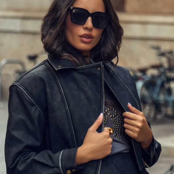 Cazadora crop gris oscuro, cruzada con cierre de cremallera dorada diagonal y solapa. Puños con botón. Fruncida en el bajo- Forro interior polar de pelito. Dos bolsillos laterales, y detalle de bolsillo y cremallera en la manga con bordado del logo de Camaleónica.  Composición: 55% poliéster, 45% poliuretano. 