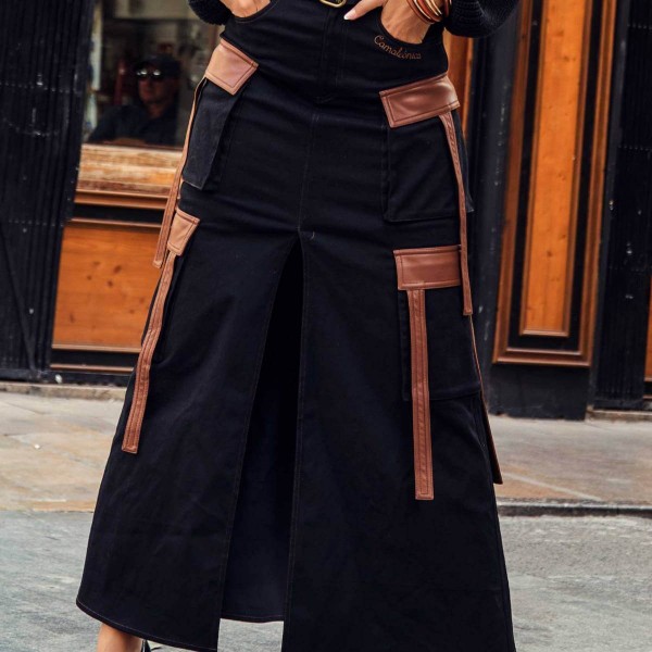 Falda larga vaquera negra estilo cargo con multibolsillos, con detalles en ecopiel en color marrón. Dos bolsillos laterales. Abertura central. Cinturilla marrón de ecopiel. Cierre con botón y cremallera. Composición: 97% algodón, 3% elastano