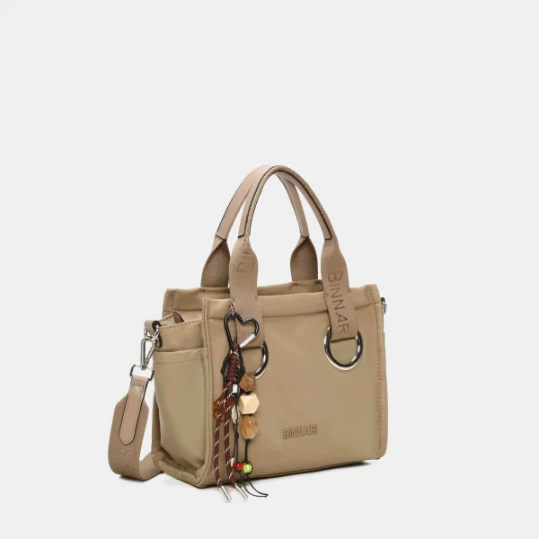 Fabricado en nylon resistente, combina asas anchas con aros metálicos que le dan un toque muy actual. Incluye un detalle decorativo extraíble y una correa regulable para usarlo también en bandolera. Compacto pero espacioso, es ese modelo que lo tiene todo: estilo, comodidad y funcionalidad. Medidas: 21*26*11