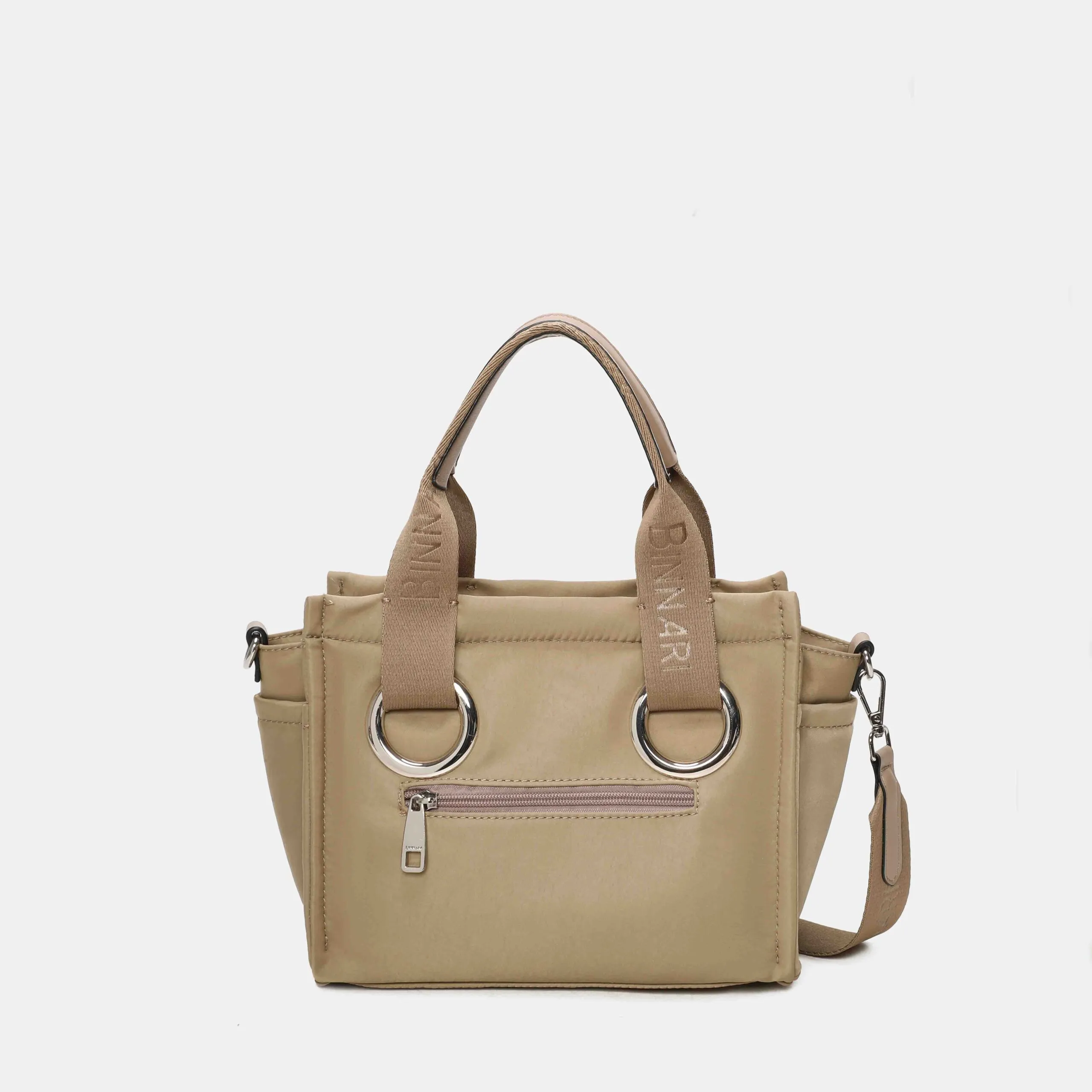 BOLSO XARA Fabricado en nylon resistente, combina asas anchas con aros metálicos que le dan un toque muy actual. Incluye un detalle decorativo extraíble y una correa regulable para usarlo también en bandolera. Compacto pero espacioso, es ese modelo que lo tiene todo: estilo, comodidad y funcionalidad. Medidas: 21*26*11