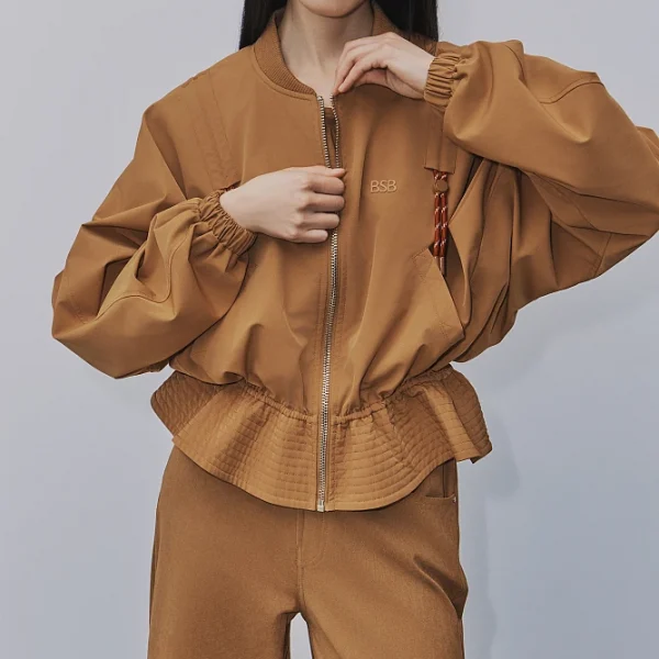 Chaqueta corta de manga larga, fruncida, cierre con cremallera, con bolsillos.