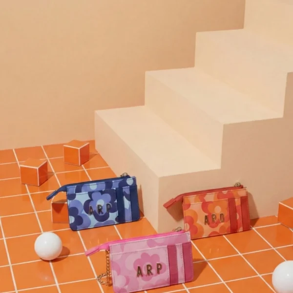 Este tarjetero de la colección de Agatha Ruiz de la Prada está diseñado en piel sintética lisa, con pequeños detalles del estampado de flores. Mantiene la estética alegre y moderna de la colección, en un formato práctico y ligero para llevar a diario. Incluye cremallera superior, ideal para guardar monedas o pequeños objetos, y varios compartimentos para tarjetas, permitiendo tener todo bien organizado sin ocupar espacio. Su diseño compacto lo hace perfecto para llevar en bolsos pequeños, bandoleras o incluso en el bolsillo. Un accesorio funcional, resistente y con el toque distintivo de Agatha, pensado para usar todos los días. Medidas: 12*8*3