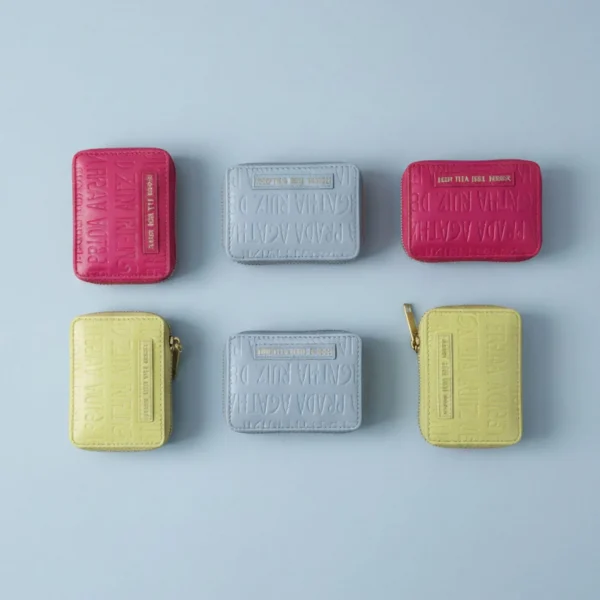 Este monedero pequeño de Agatha Ruiz de la Prada es el complemento ideal para la colección de charol en tonos pastel. Confeccionado en charol brillante, incorpora el logo de la marca grabado en toda la superficie, creando un efecto elegante y texturizado que refuerza la identidad de la firma. Cuenta con cierre de cremallera superior y tirador con el icónico icono de Agatha, aportando un detalle divertido y distintivo. Su tamaño compacto permite llevar tarjetas, monedas y pequeños objetos de forma cómoda y organizada, convirtiéndolo en un accesorio funcional para el día a día. Un monedero ligero, práctico y muy combinable, perfecto para llevar dentro de un bolso más grande o usarlo solo como accesorio de organizacion. Medidas: 11*9*3