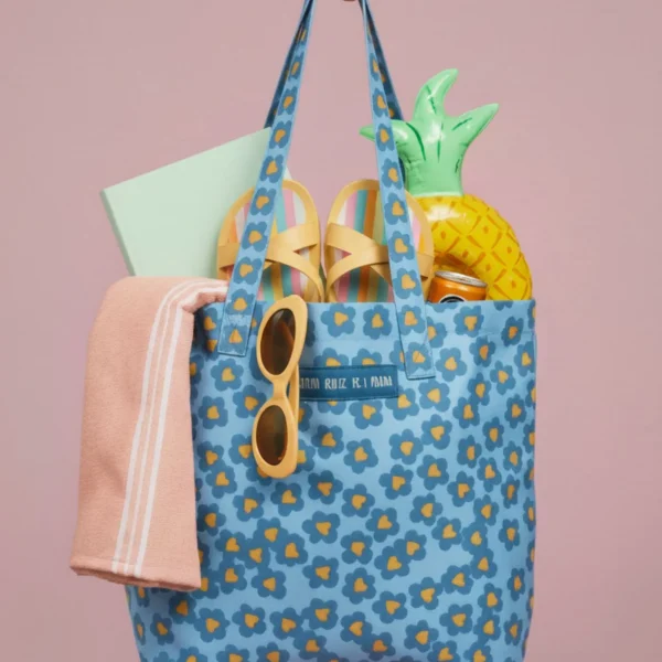Esta bolsa tote de Agatha Ruiz de la Prada es una opción práctica y estilosa para el día a día. Confeccionada en tela reforzada, ofrece resistencia y durabilidad, convirtiéndose en un complemento perfecto para acompañarte en cualquier rutina. Su diseño incorpora los característicos estampados de la firma, con iconos y logos de Agatha Ruiz de la Prada que aportan color, personalidad y ese aire divertido tan reconocible de la marca. En el centro destaca el logo de Agatha en piel vegana a contraste, aportando un toque diferencial y elevando el acabado del bolso. Gracias a su formato amplio, resulta ideal para llevar en el coche, utilizar para pequeñas compras, recados o como bolso auxiliar diario. Un tote cómodo, ligero y funcional que combina practicidad con diseño. Un básico imprescindible para quienes buscan una bolsa versátil, resistente y con el sello inconfundible de Agatha Ruiz de la Prada. Medidas: 35*38